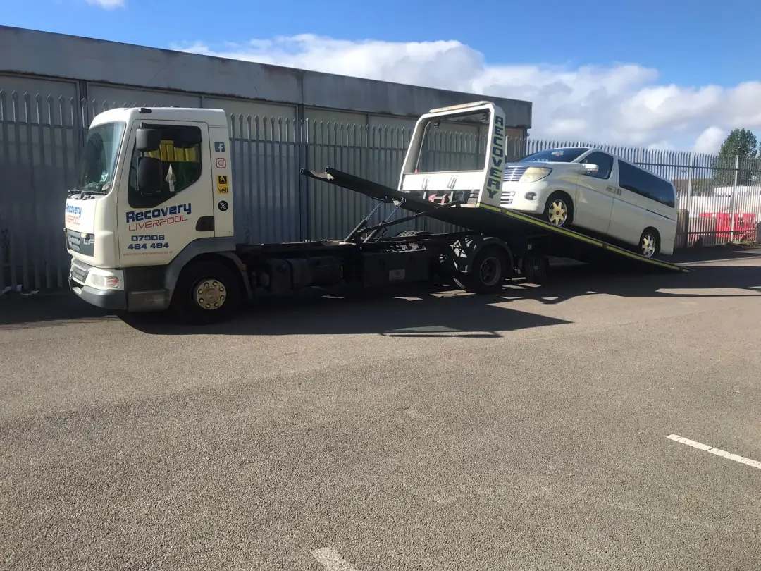 People carrier being winched up the tilted bed of our recovery truck